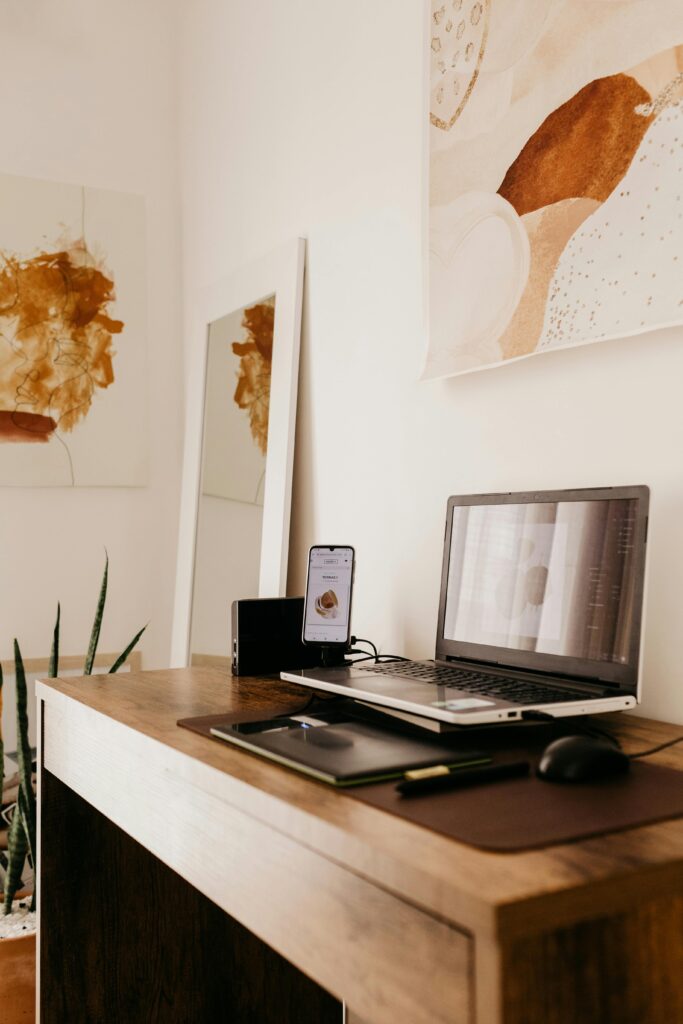 Interior of modern workspace with laptop and different technological devices in light room